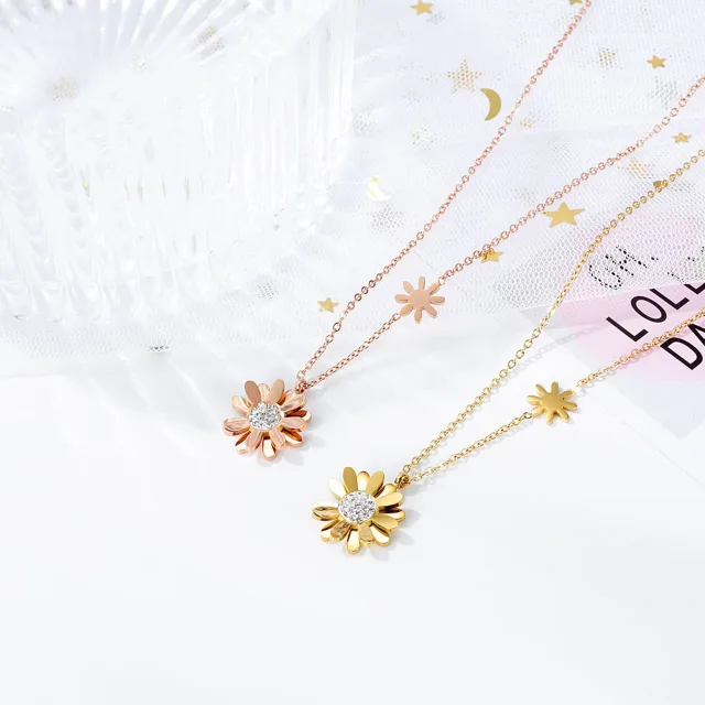 Three daisy pendants in gold, rose gold and pink