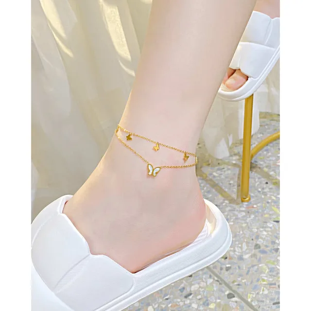 Ankle wearing the anklet beside a gold stand