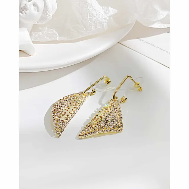Gold triangle earrings, close view on linen