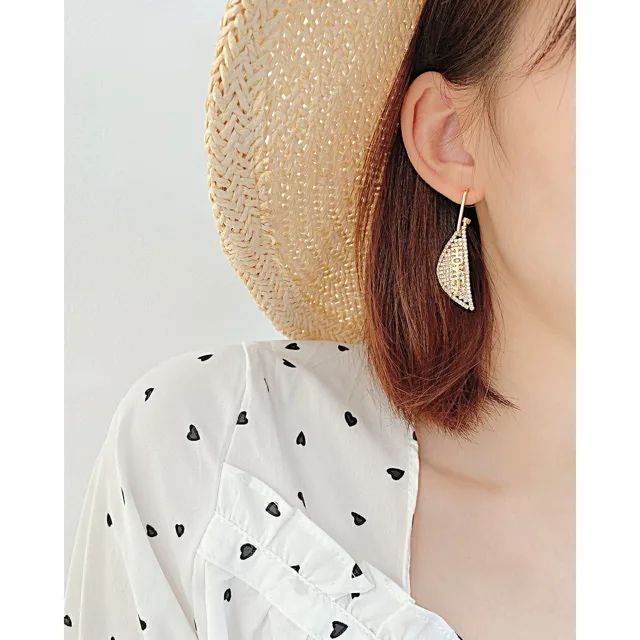 Model in a straw hat wearing the earrings