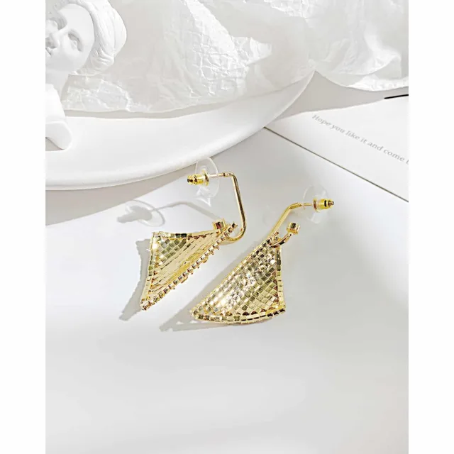Gold triangle earrings laid on white linen