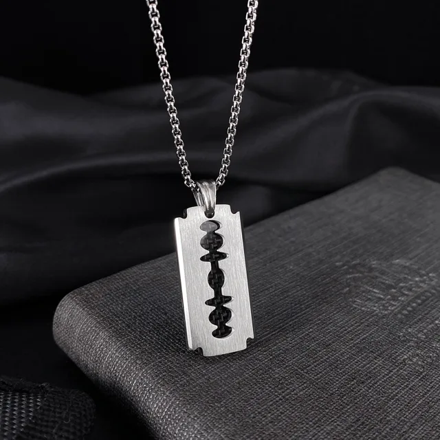 Blade pendant resting on dark stone