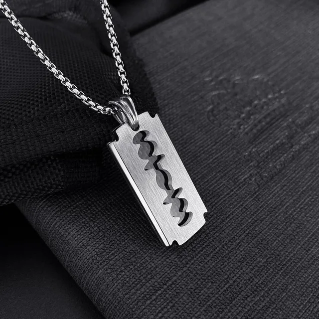 Razor-blade pendant on black fabric, close view