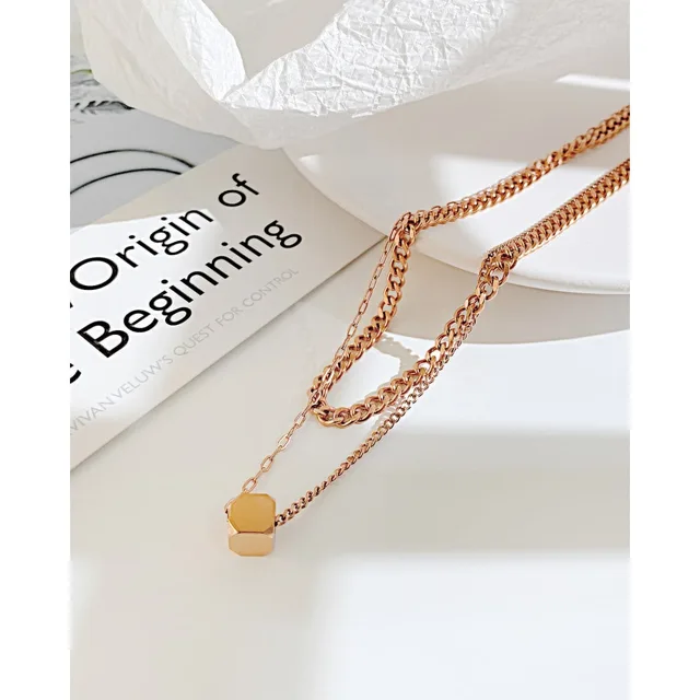 Rose gold layered necklace on white linen