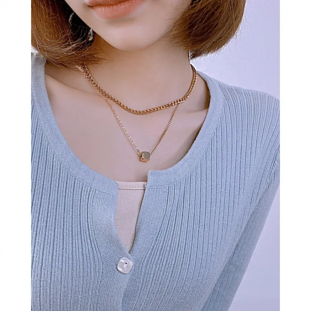Model in a blue cardigan wearing the layered necklace