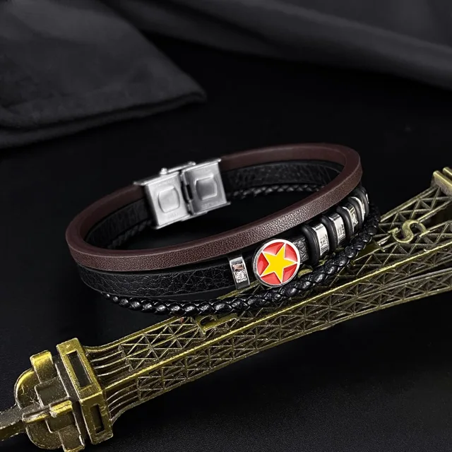 Leather bracelet beside a miniature Eiffel tower