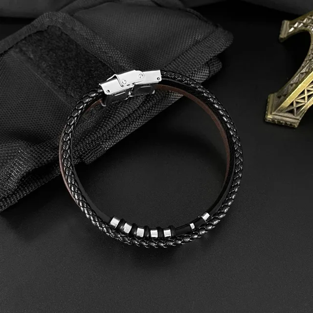 Black leather bracelet laid on dark fabric