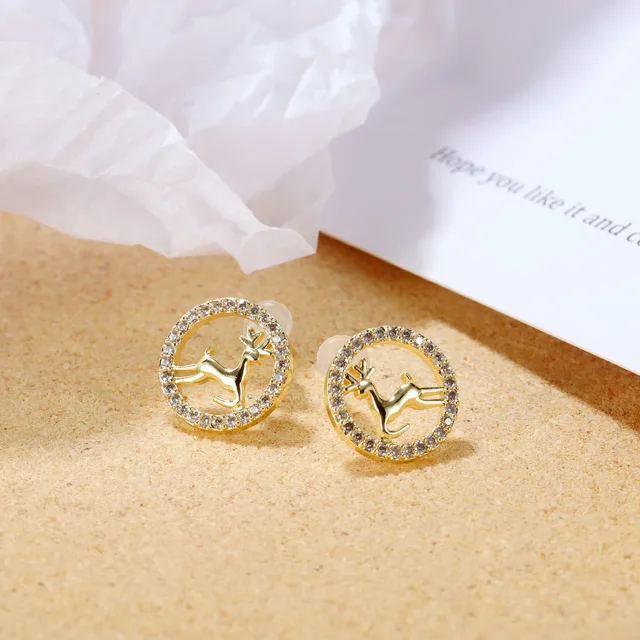 Gold deer studs on a sand-coloured surface