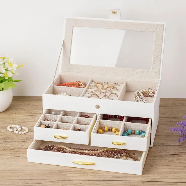 Cream jewelry box styled open on a wooden table with flowers