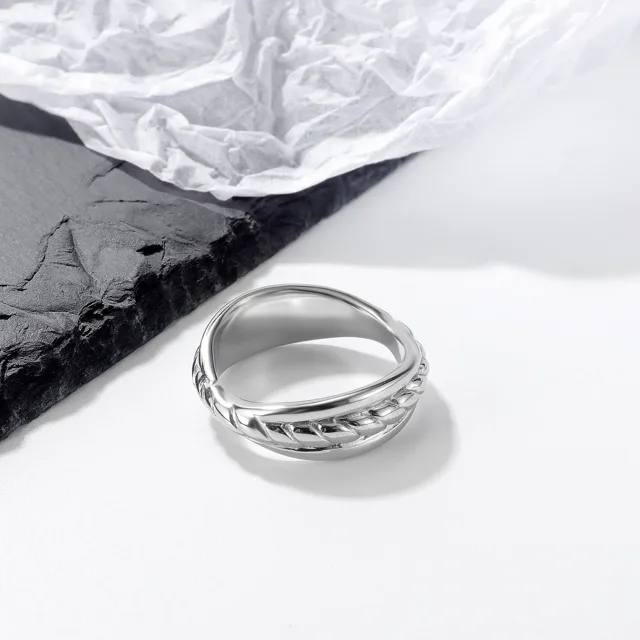 Silver braided ring on white paper and slate