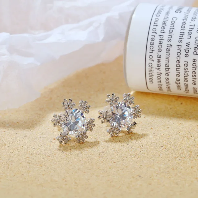 Snowflake studs laid beside a rolled newspaper