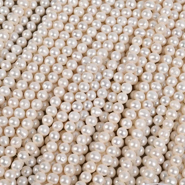 Close-up of pearl strand rows showing off-round and baroque shapes in cultured freshwater pearls