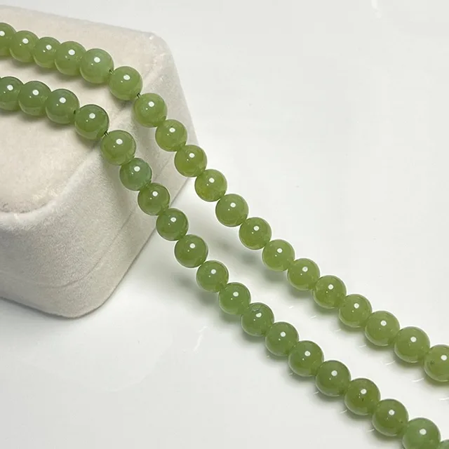 Loose jade bead strands laid out on a velvet tray
