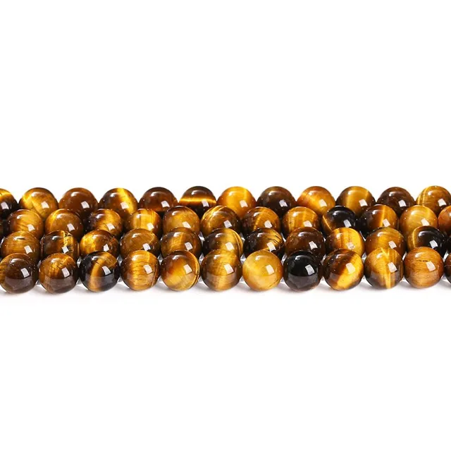 Round tiger's eye bead strands laid in rows showing golden banding, bracelet components
