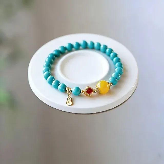 Multi-wrap turquoise bead bracelet with red and black accent beads and gold-tone spacer rings