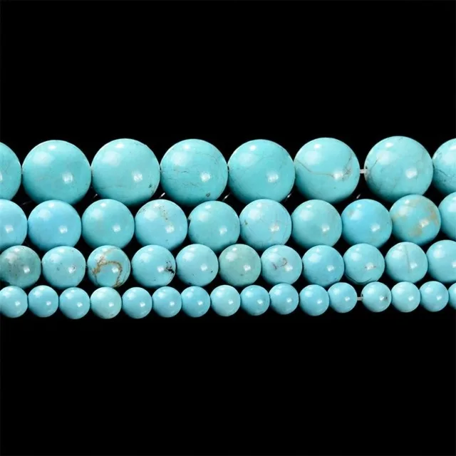Round turquoise beads laid in four rows showing natural veining, turquoise bracelet components