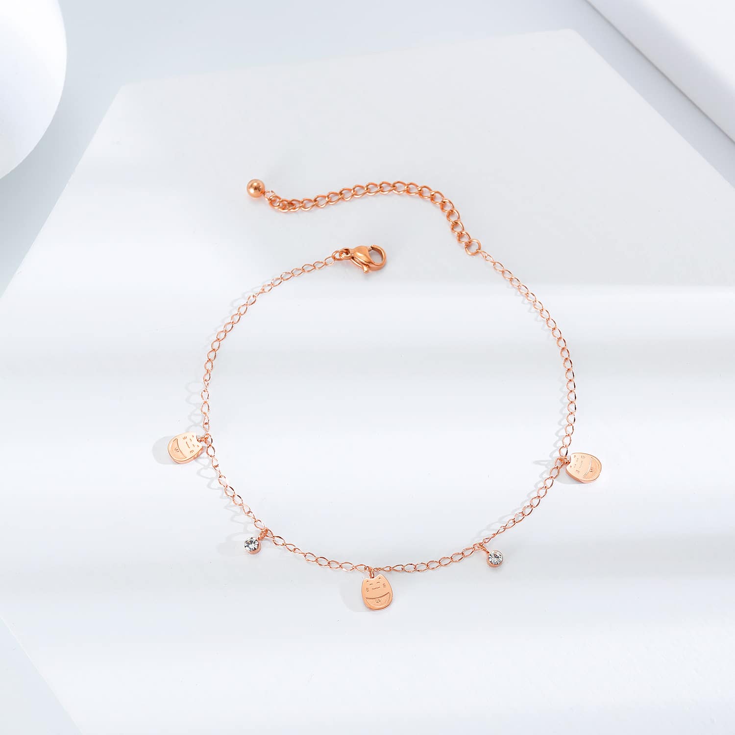 Rose gold disc anklet laid flat on white