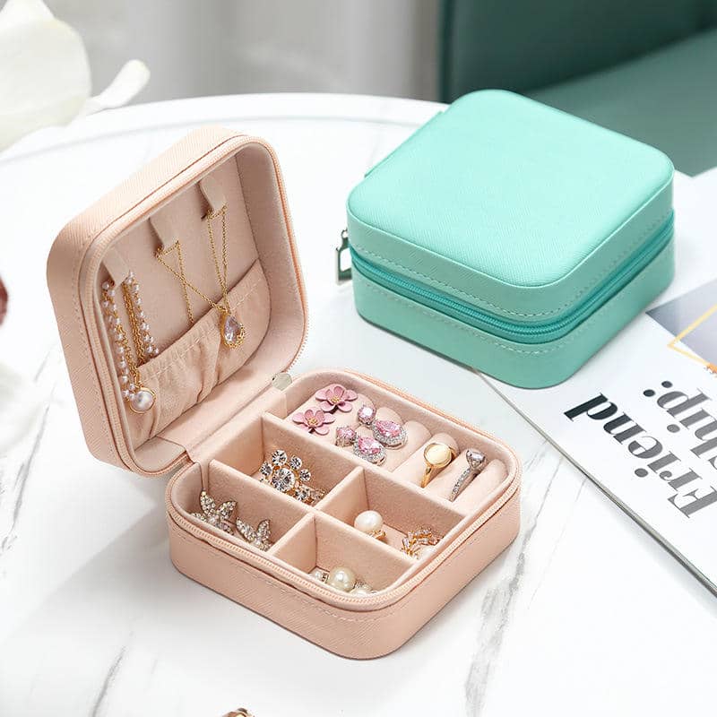 Blush square jewelry case open beside a mint closed case
