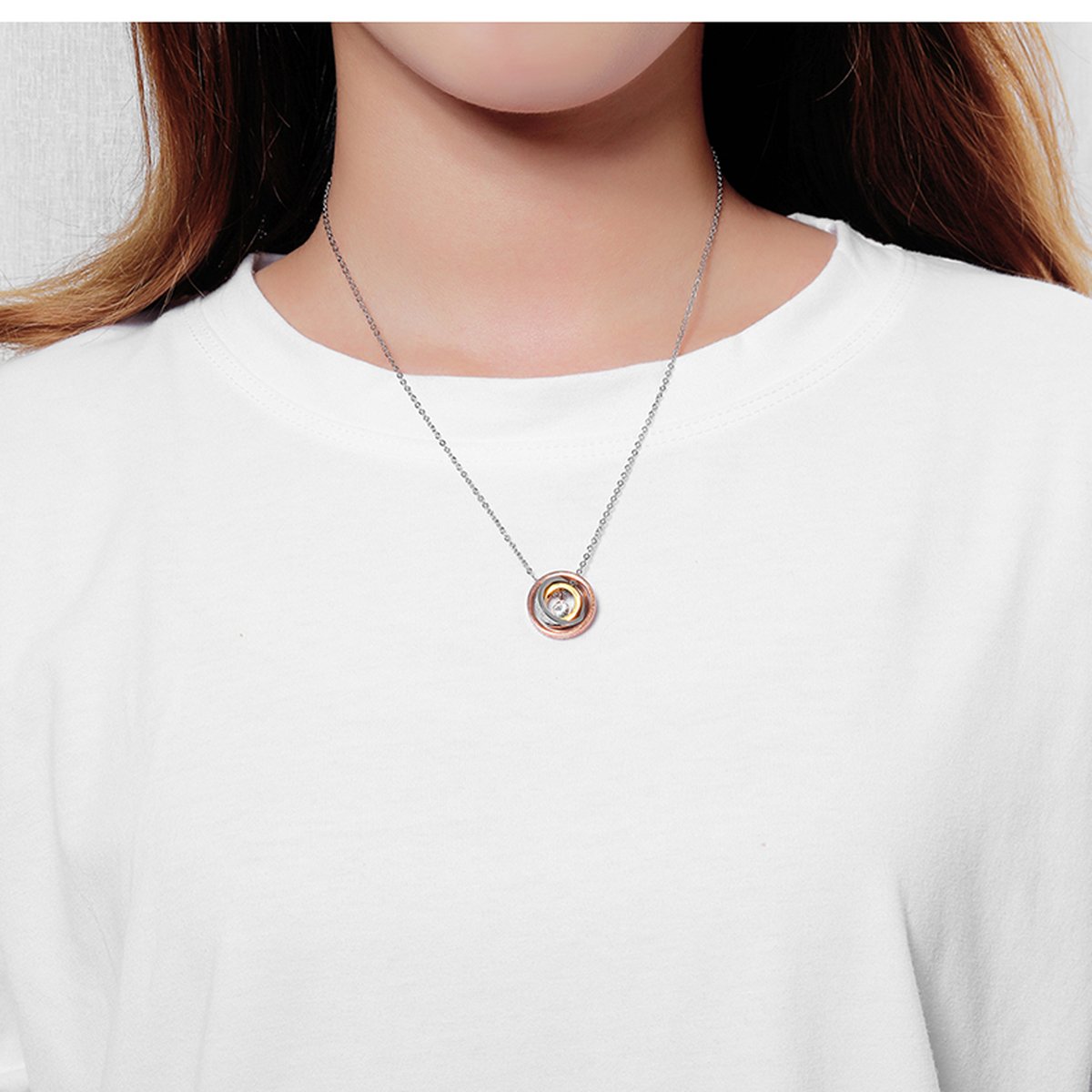 Two-tone MOM pendant necklace closeup showing engraved lettering and CZ stone