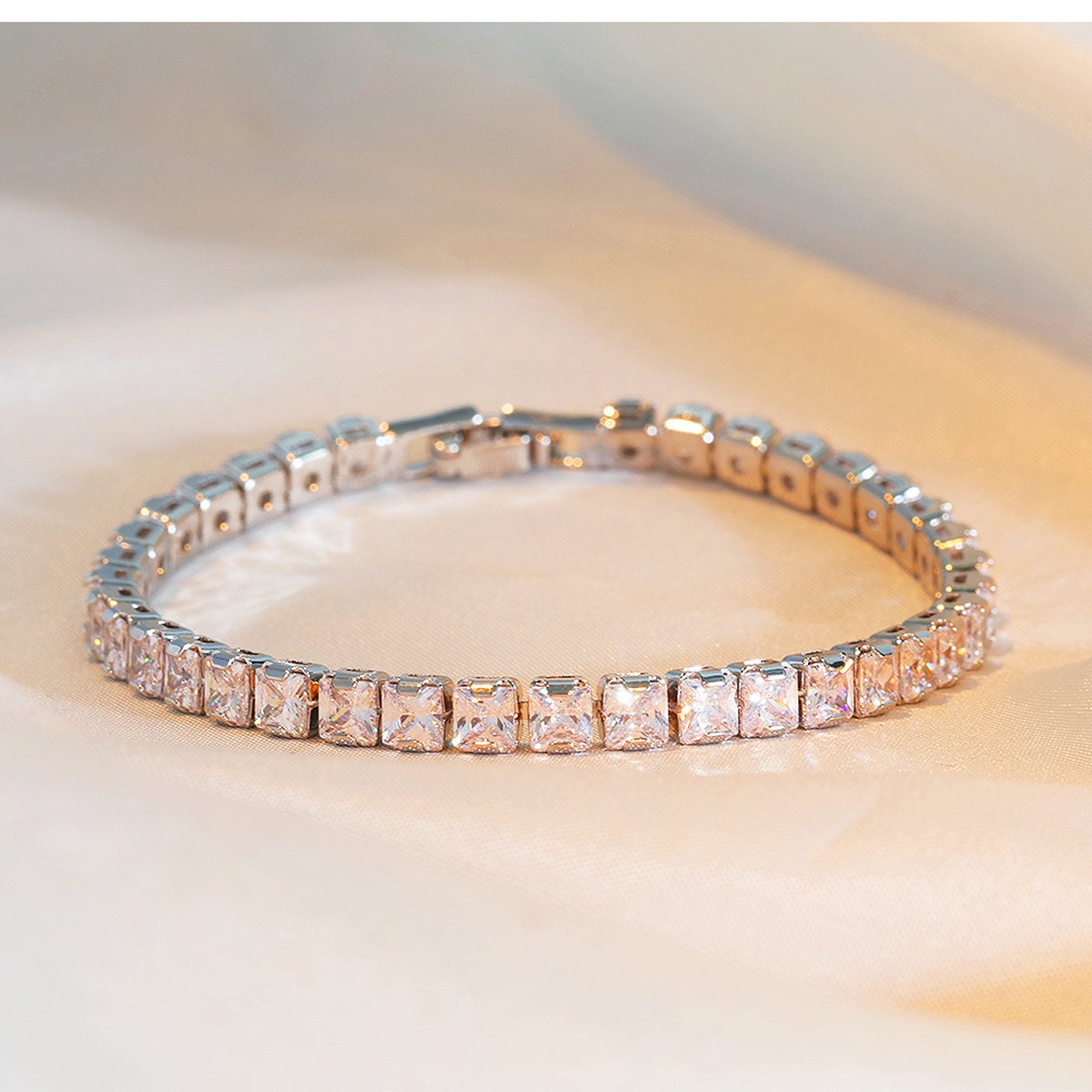 Rose gold square cubic zirconia tennis bracelet on beige fabric